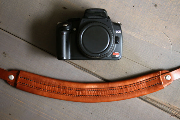 tan leather camera strap with metal hardware